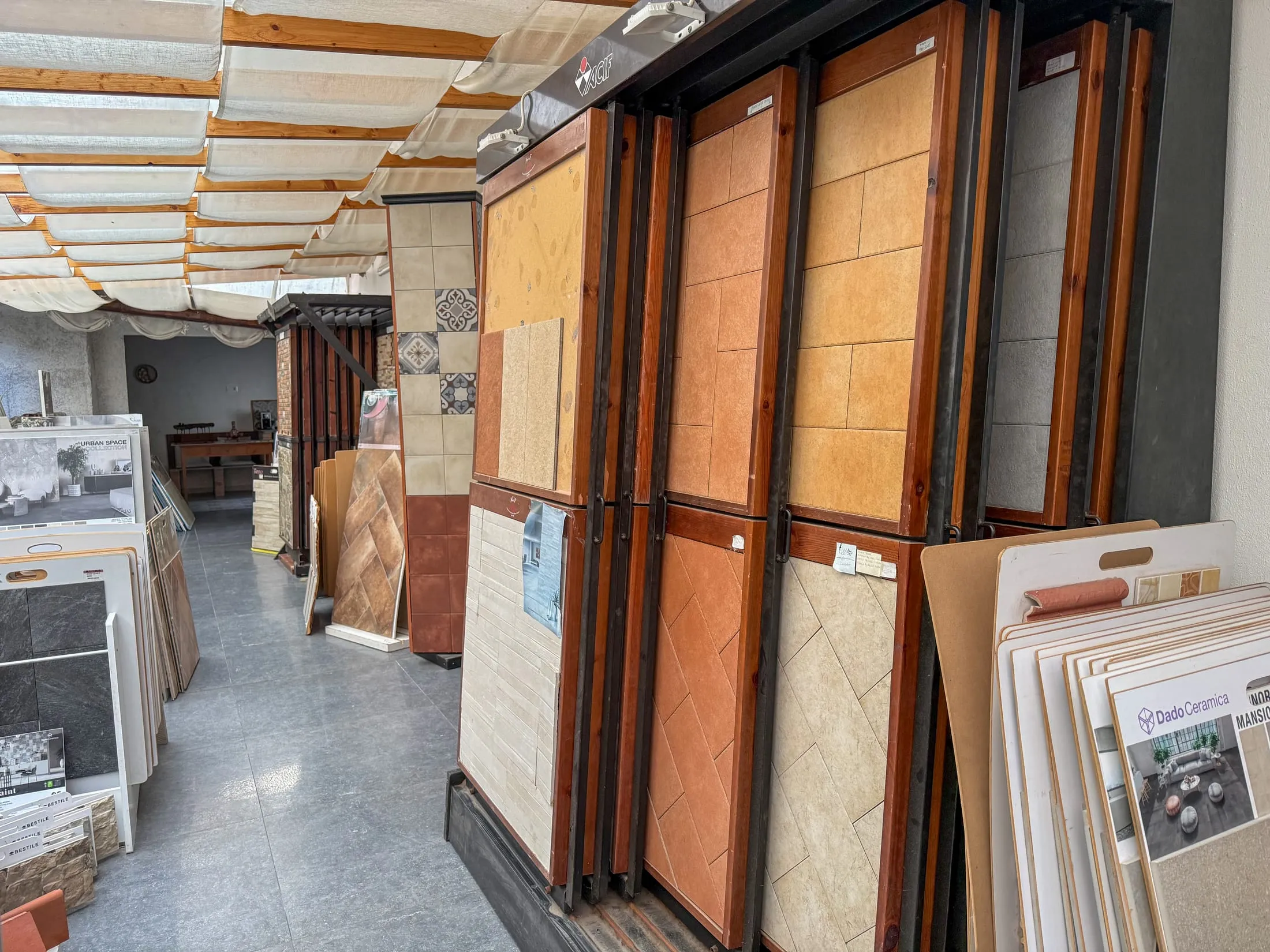 Galleria coperta con espositori in cotto e legno e piante verdi