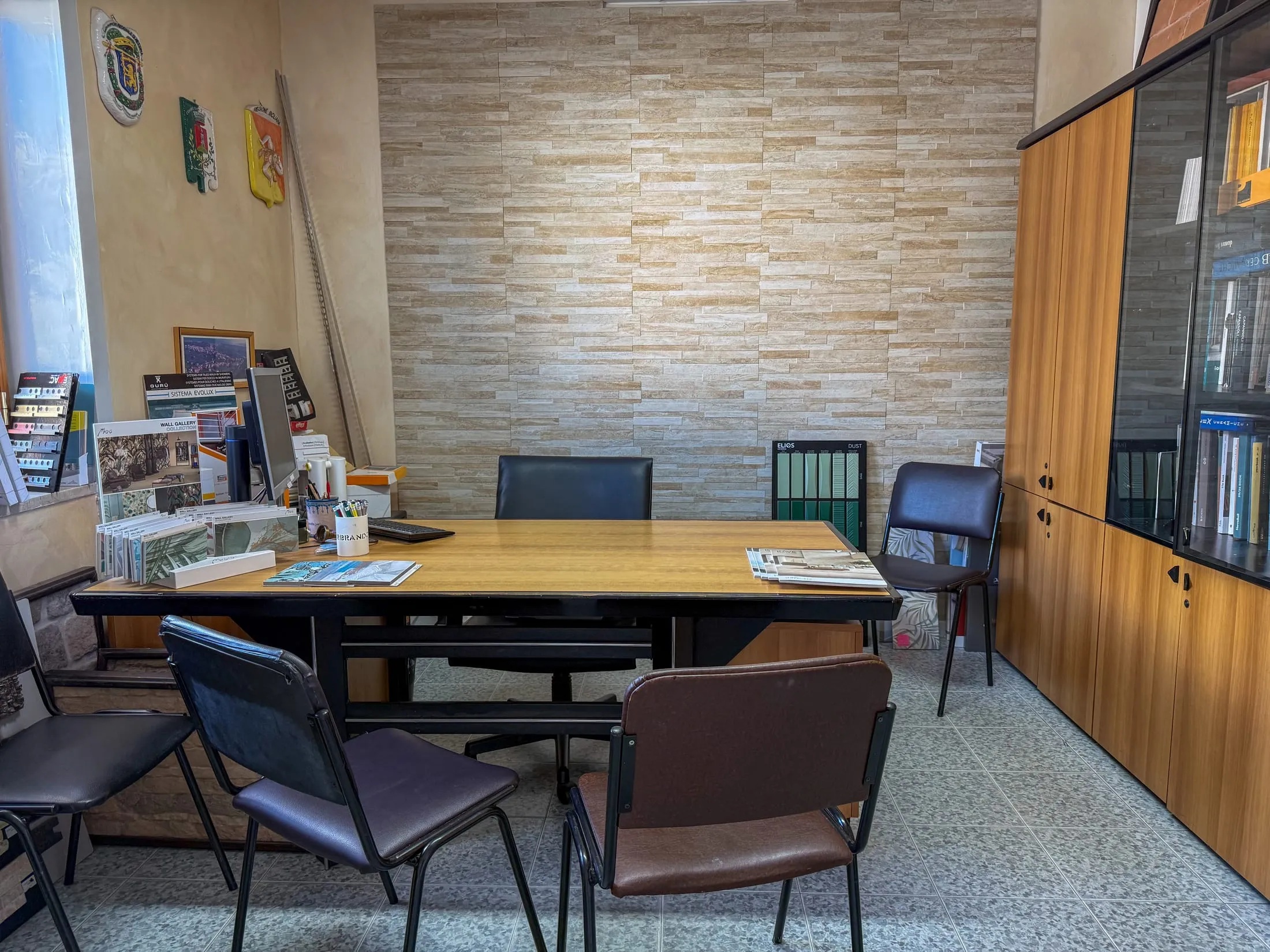 Sala consulenza dello showroom Edil Centro con tavolo e parete in pietra