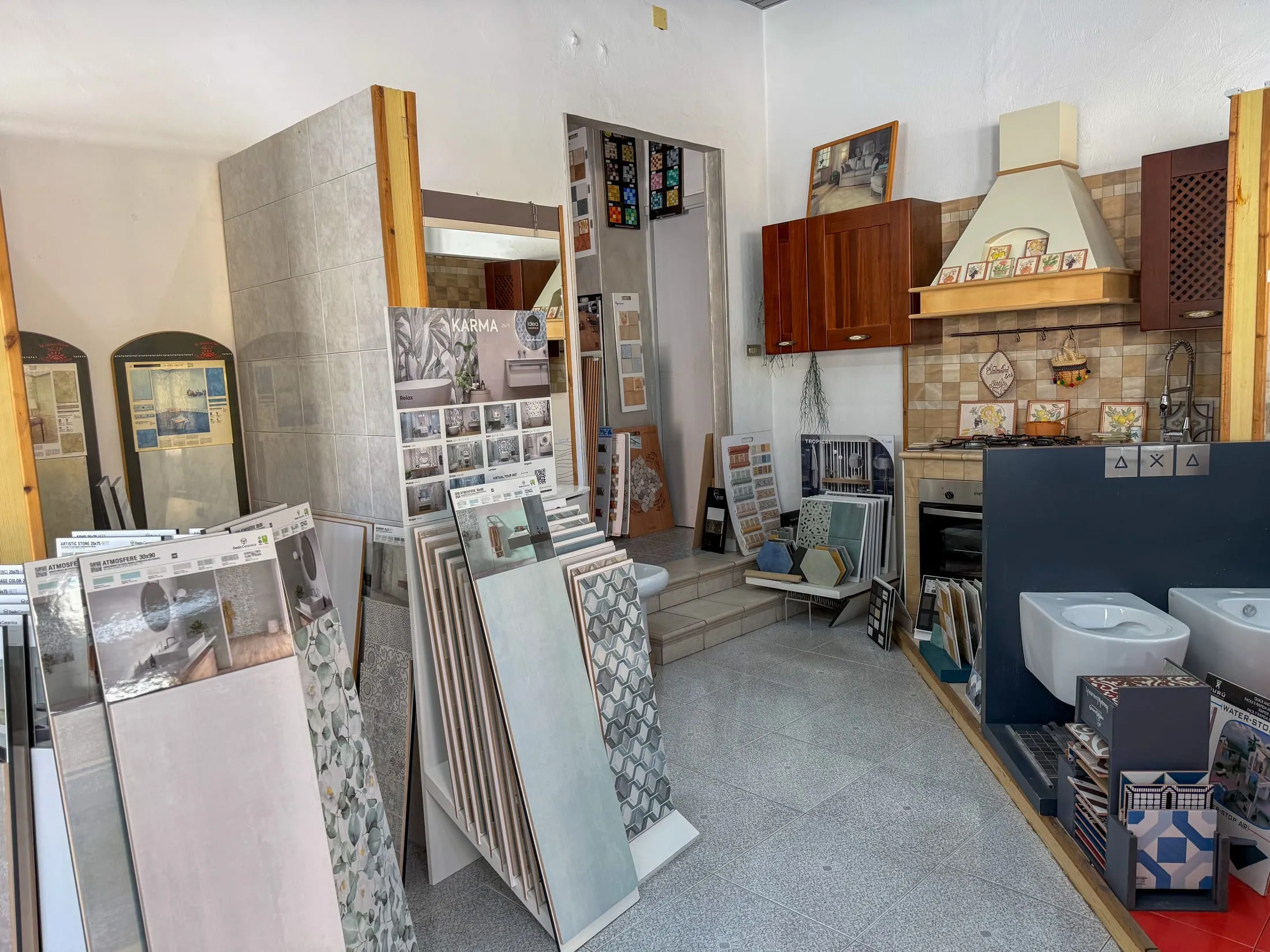 Sala dello showroom con ceramiche, camini e sanitari
