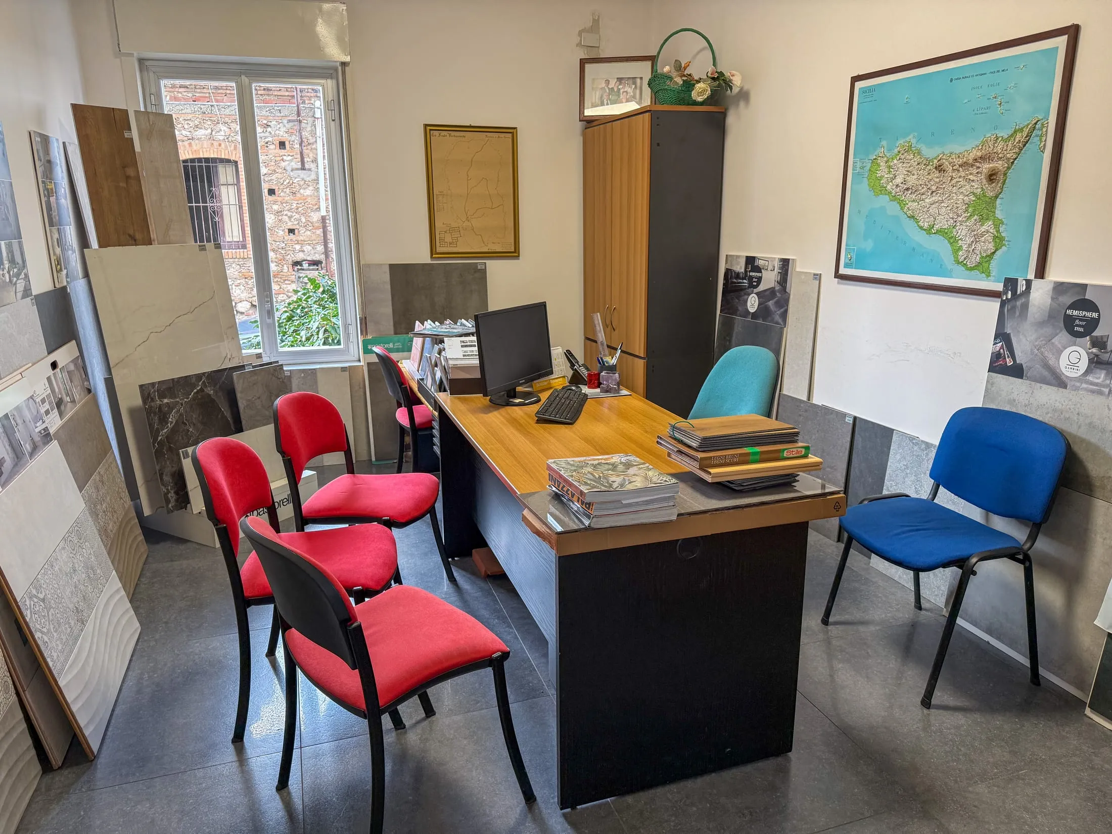 Ufficio di consulenza dello showroom con scrivania e carta della Sicilia